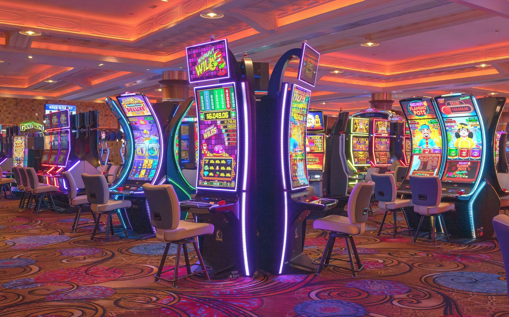 Een casino met gokkasten en speelstoelen.