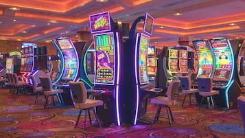 A casino with slot machines and gaming chairs.