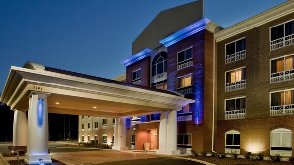 A multi-story hotel with a covered entrance and a brick facade.