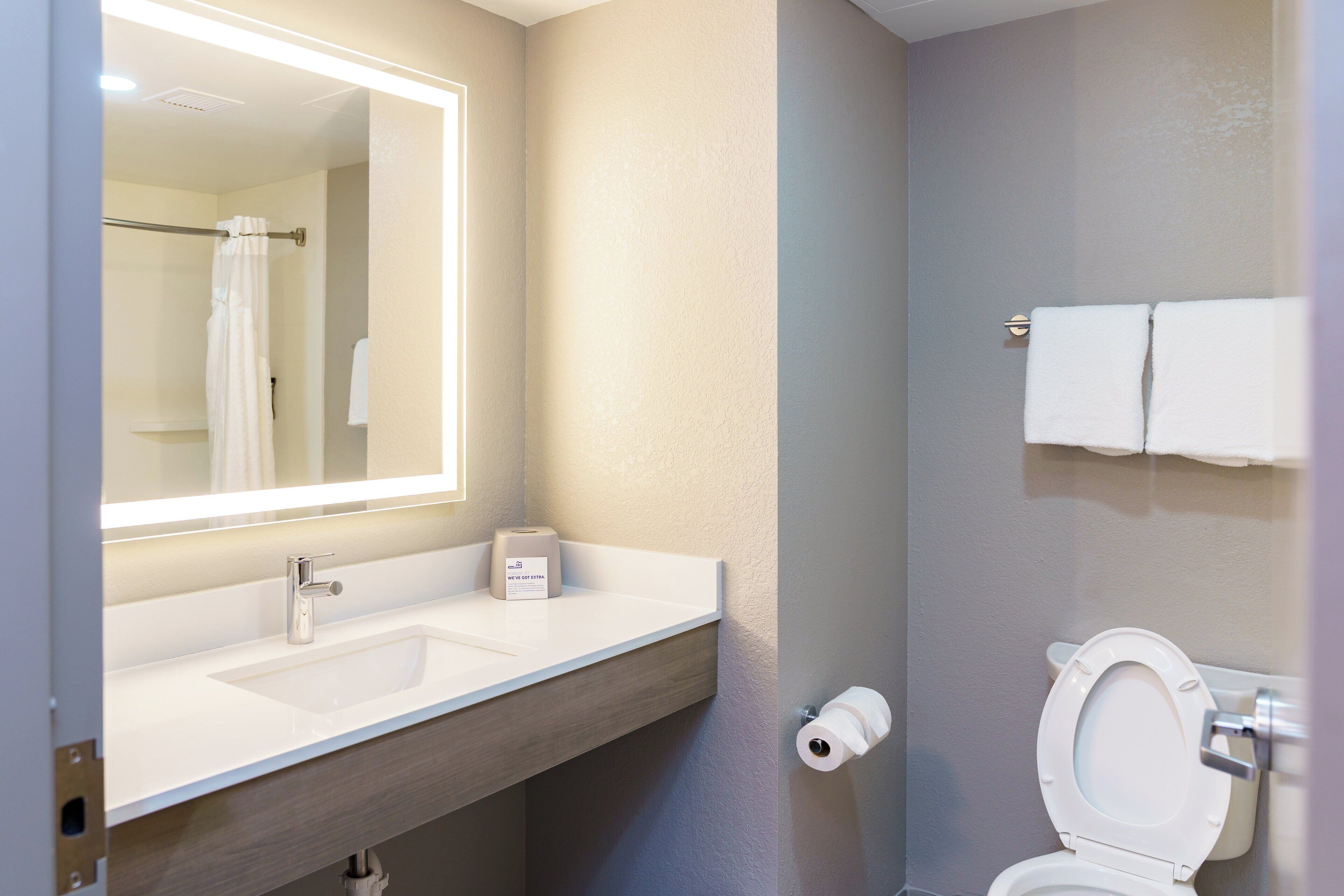 A bathroom with a sink, mirror, towel rack, and toilet.