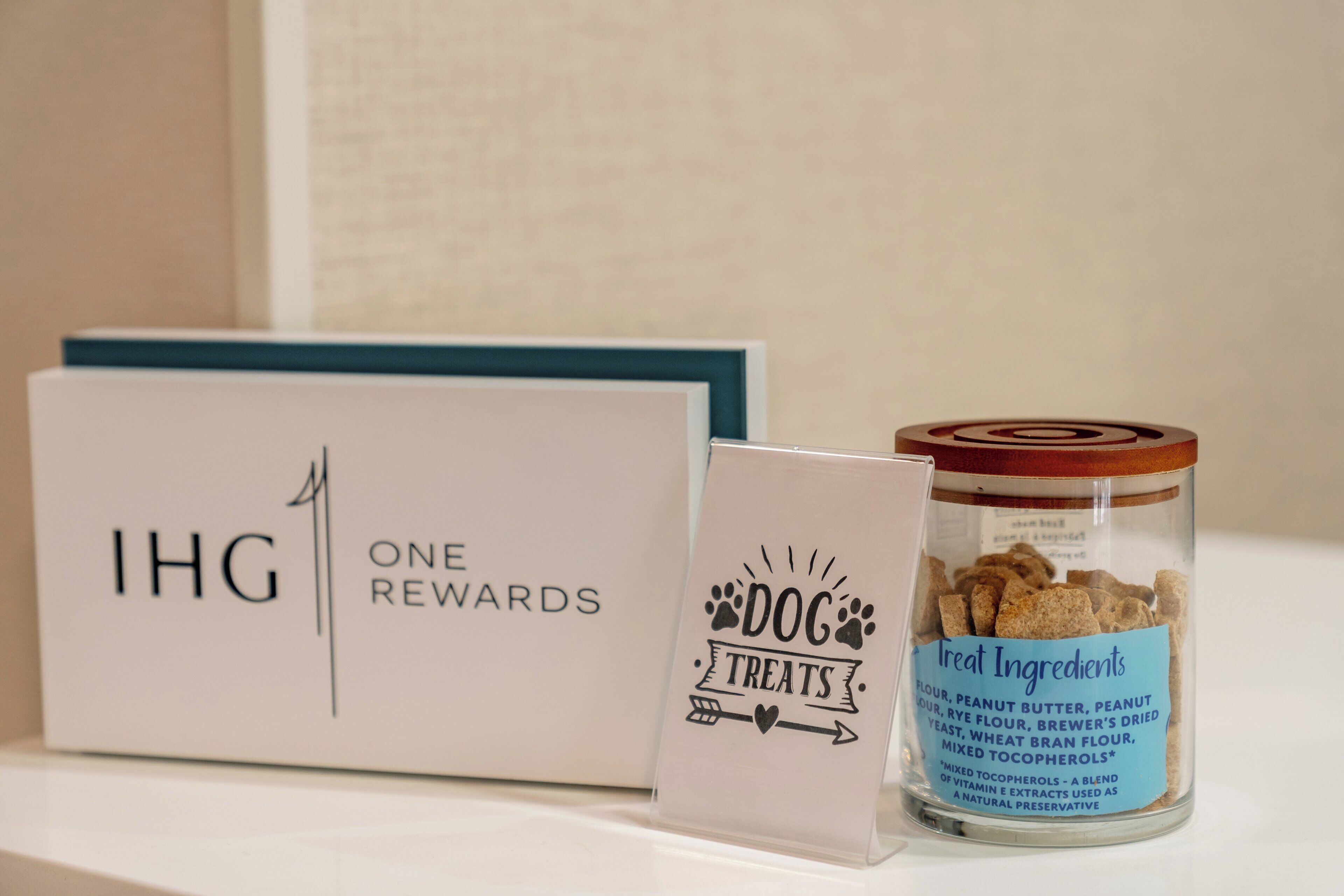 A box labeled "IHG ONE REWARDS" and a jar of dog treats with a label reading "Great Ingredients."