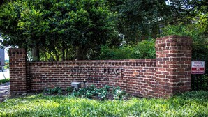 Eine Ziegelmauer mit der Aufschrift "WILLIAM BEAUX UNIVERSITY" und einem Schild mit der Meldung "PRIVATE PROPERTY NO TRESPASSING".