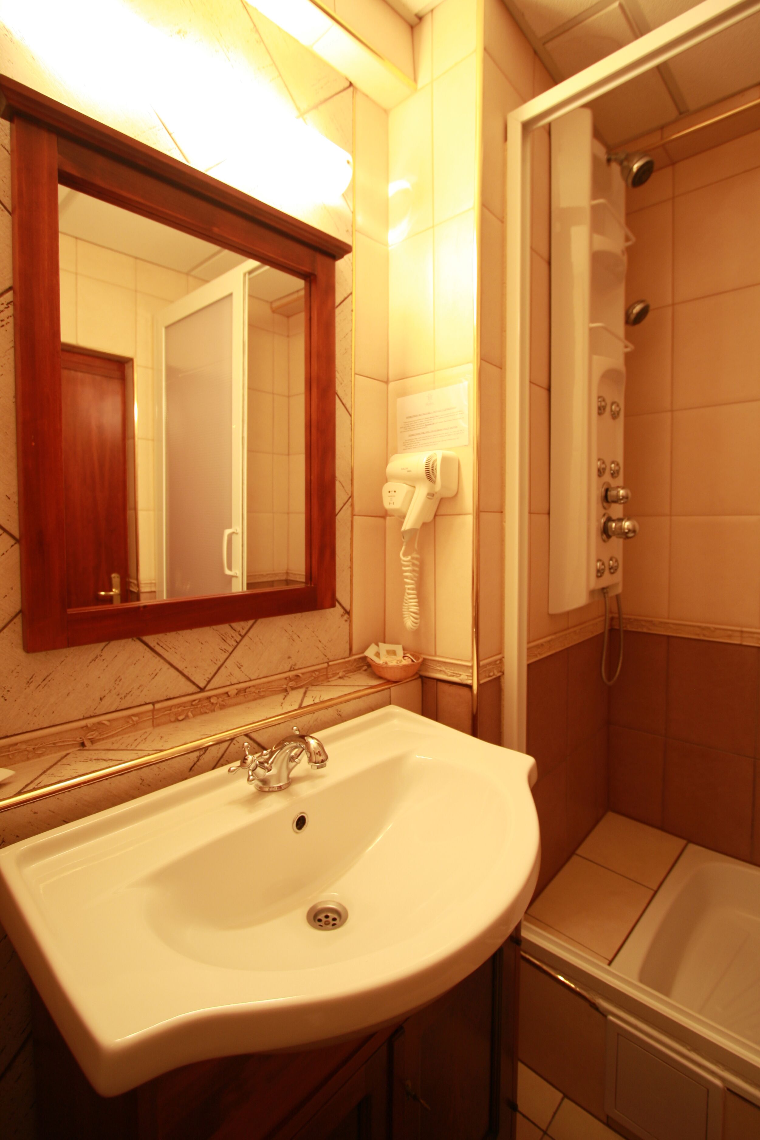 Un baño con lavamanos, espejo y ducha.