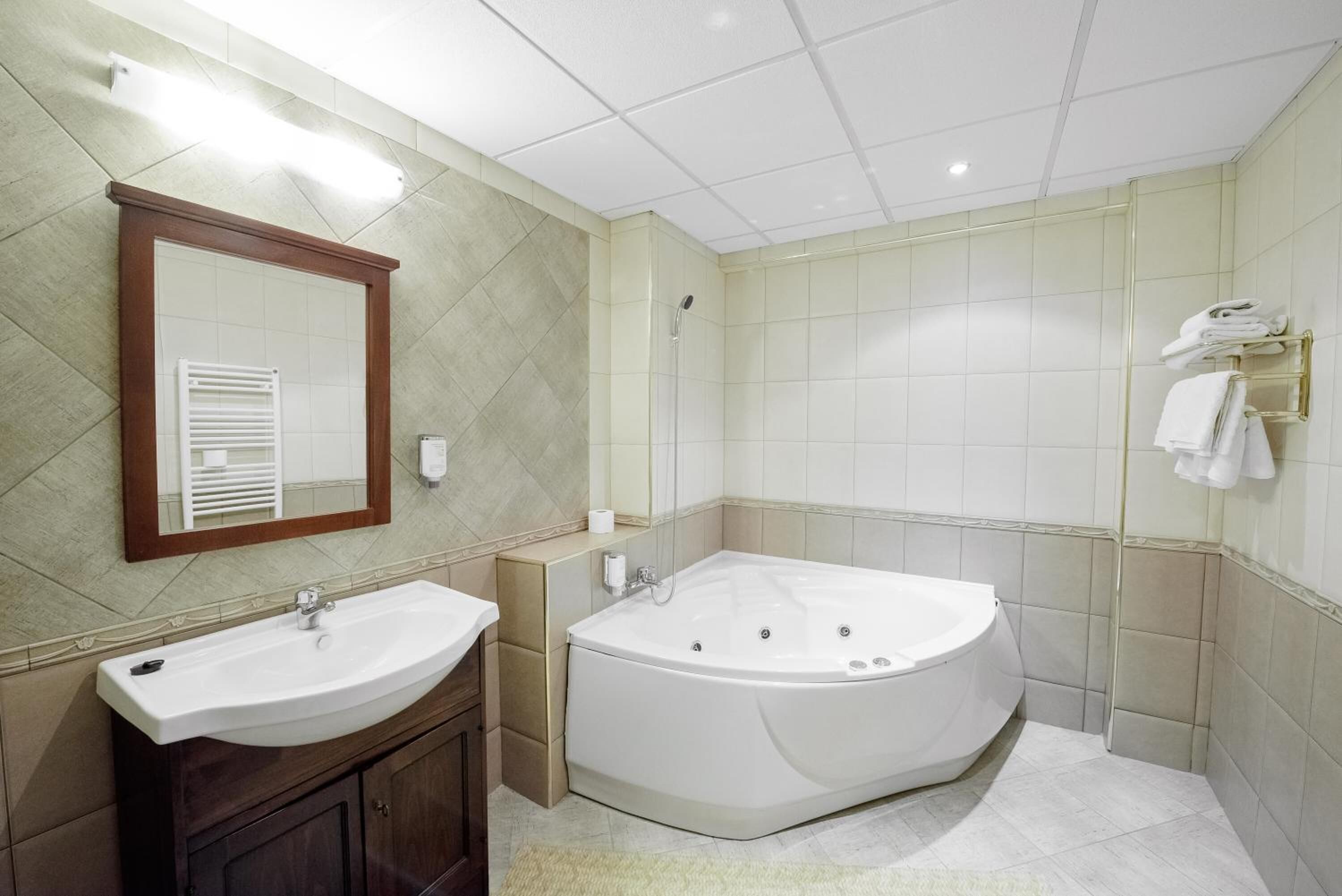 Un baño moderno con una bañera independiente, un tocador con lavabo y un espejo.