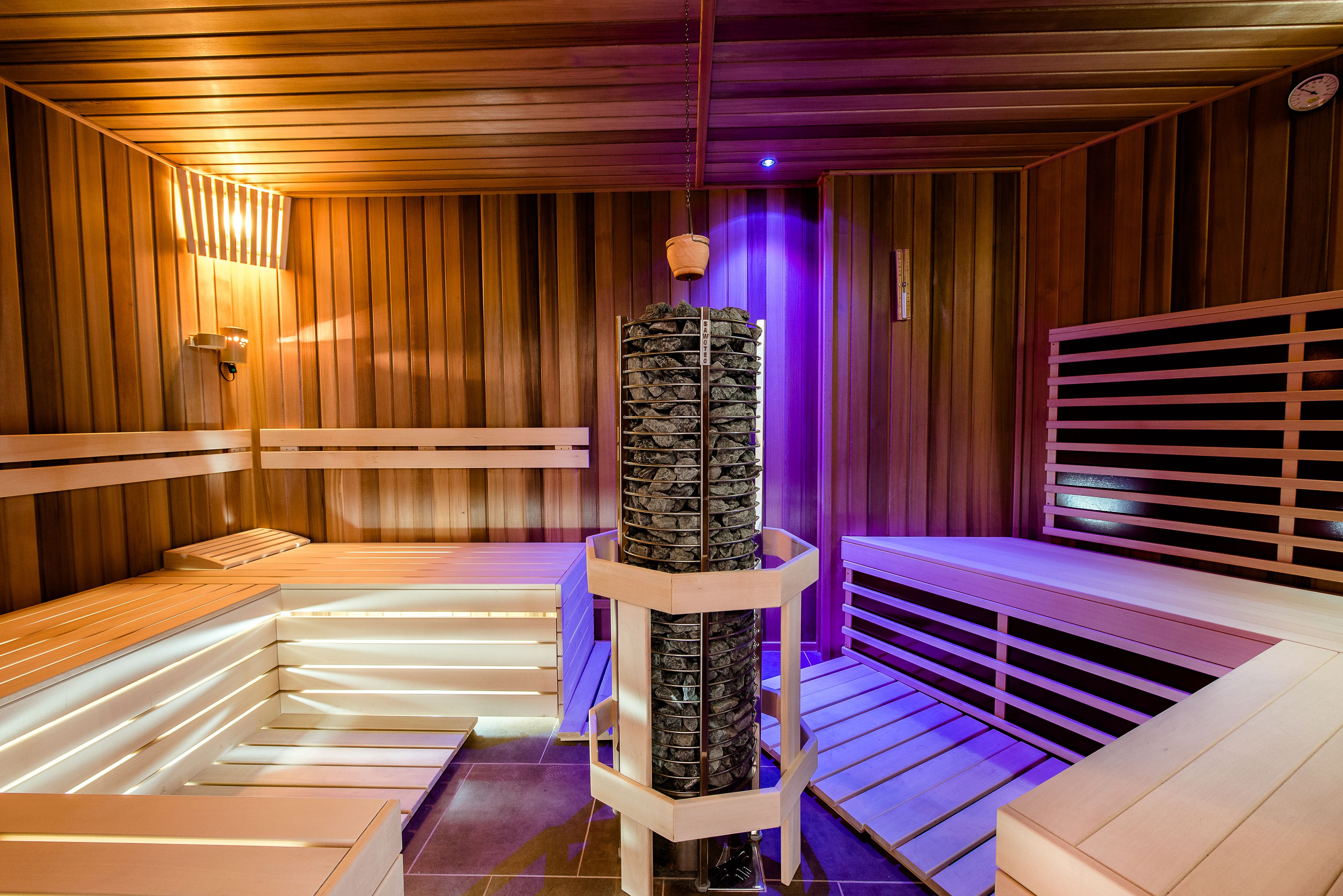 Eine Sauna mit hölzernen Bänken und einer zentralen Säule.