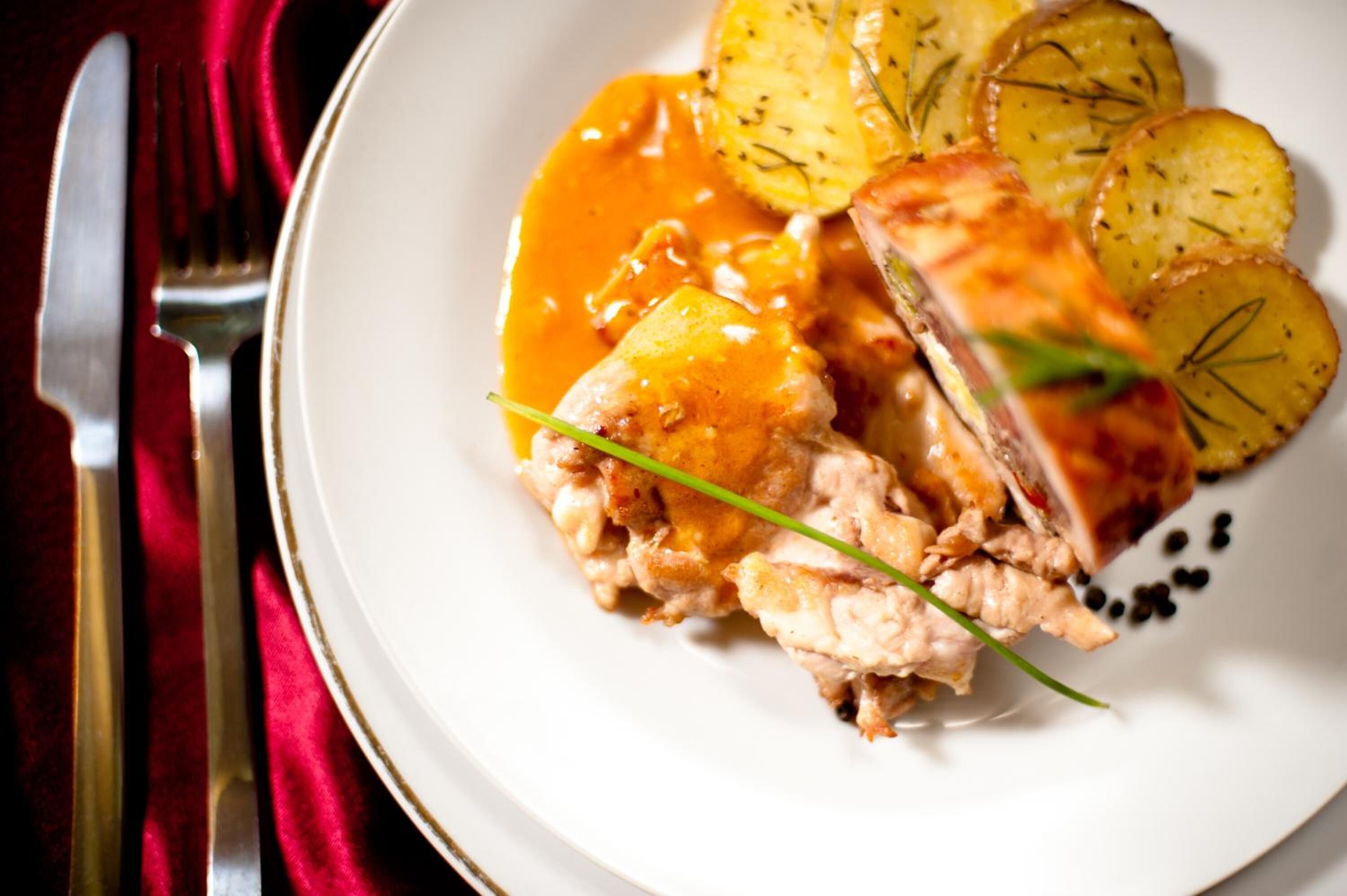 Ein Teller mit geschnittenem Fleisch, Kartoffeln und Soße.