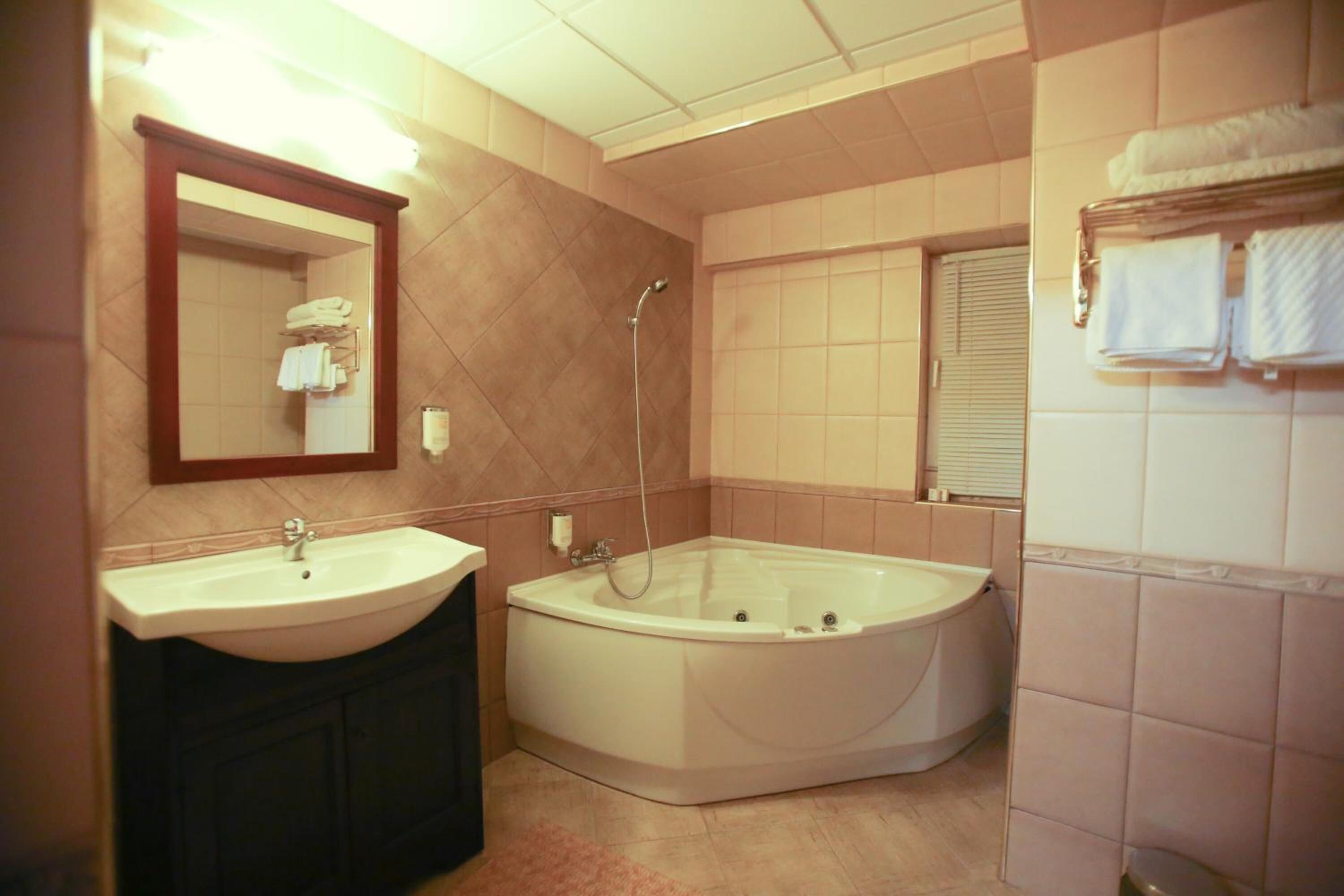 Un baño con lavabo, bañera y espejo.