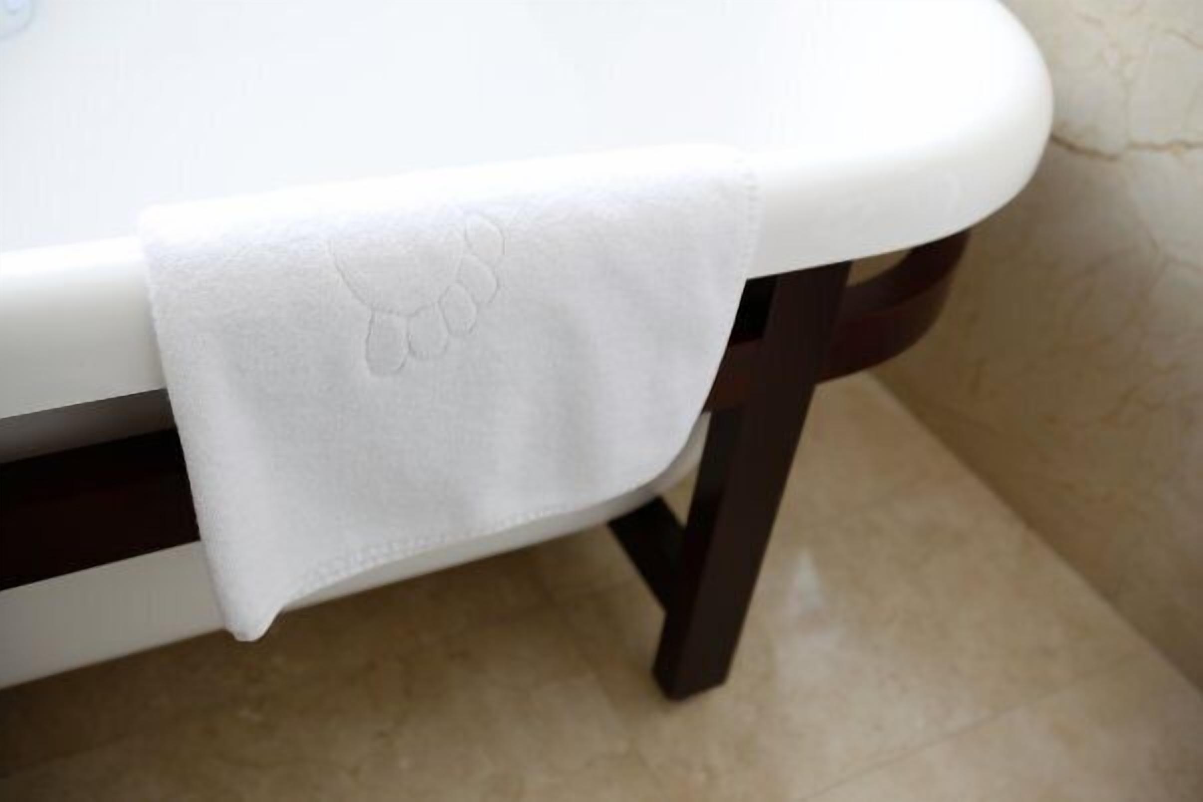 Una encimera de baño blanca con una toalla doblada.