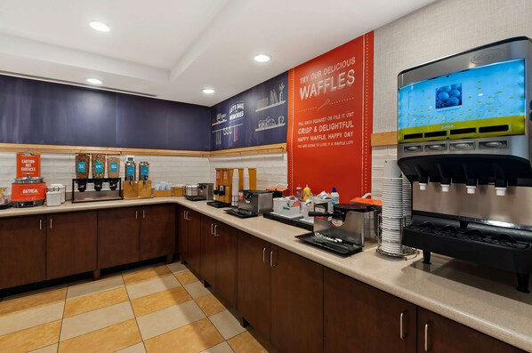 A self-service breakfast area with waffle stations, coffee machines, and a juice dispenser. - Hampton Inn & Suites Fort Belvoir Alexandria South (Alexandria)