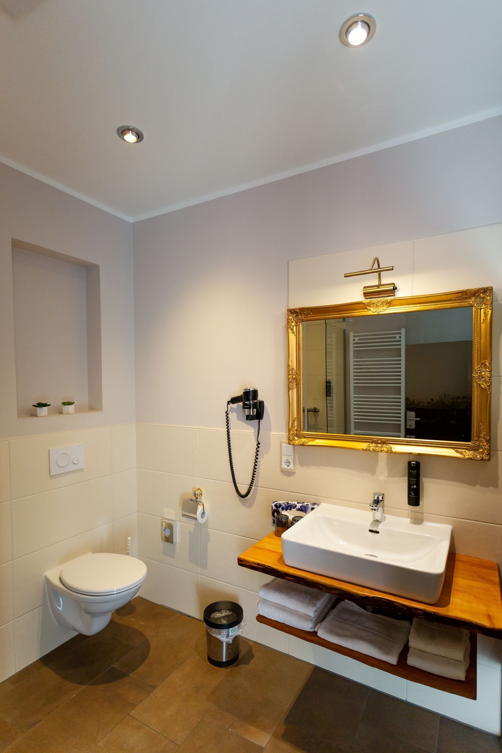 Un baño con inodoro, lavamanos y espejo.