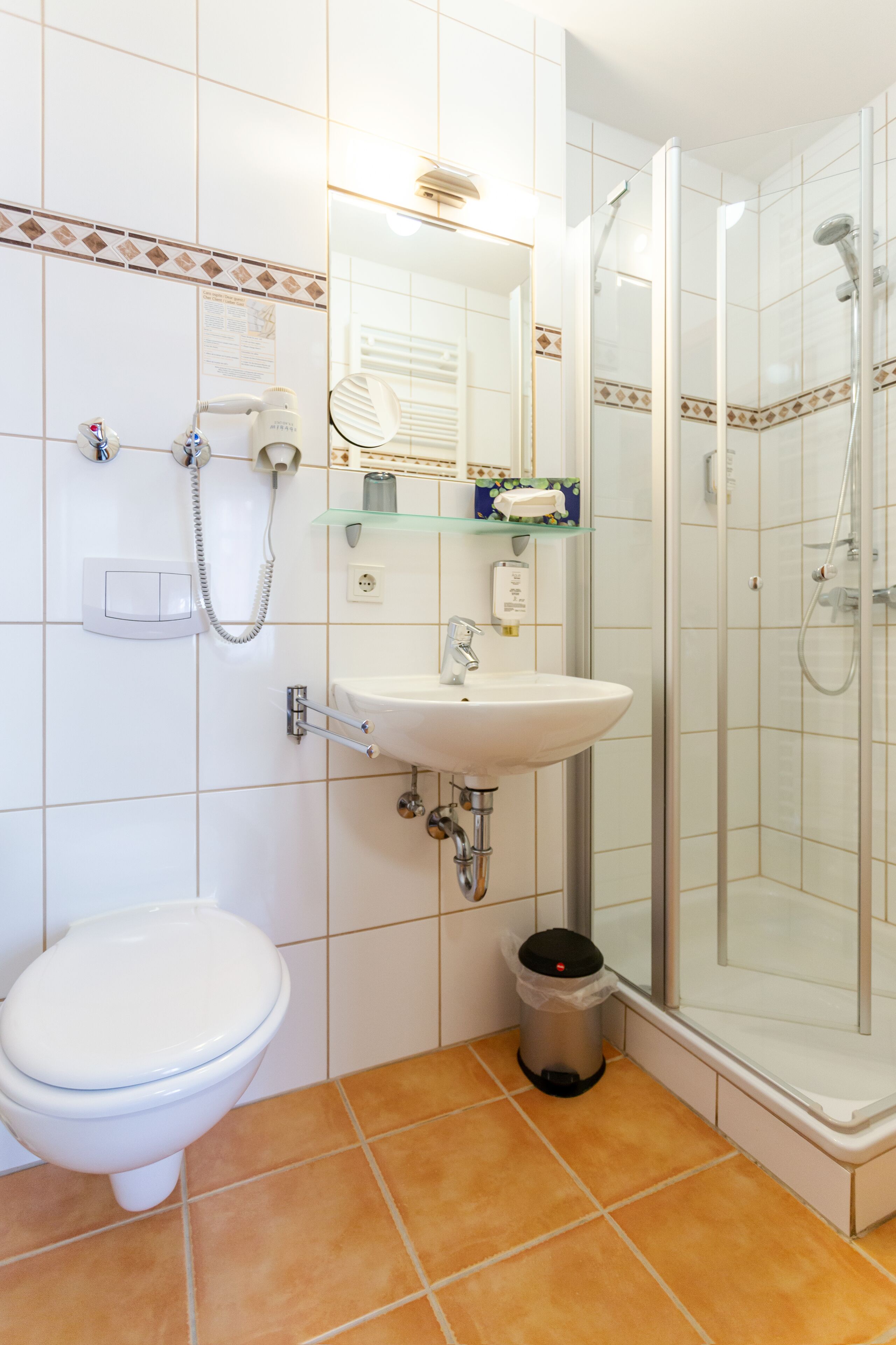 A bathroom with a toilet, sink, and glass-enclosed shower.
