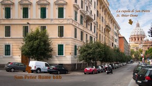 Vista de una calle en San Pedro, Roma, mostrando un b&b de arquitectura clásica y coches estacionados.