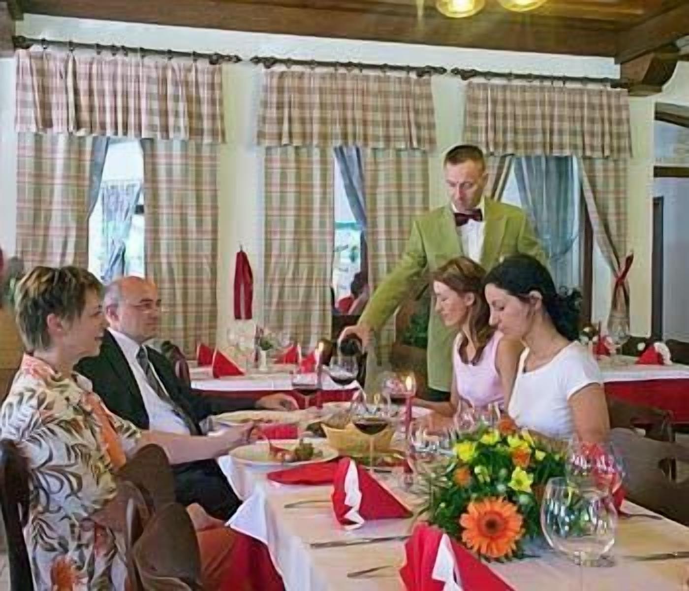 A dining table set with plates, glasses, and a centerpiece.