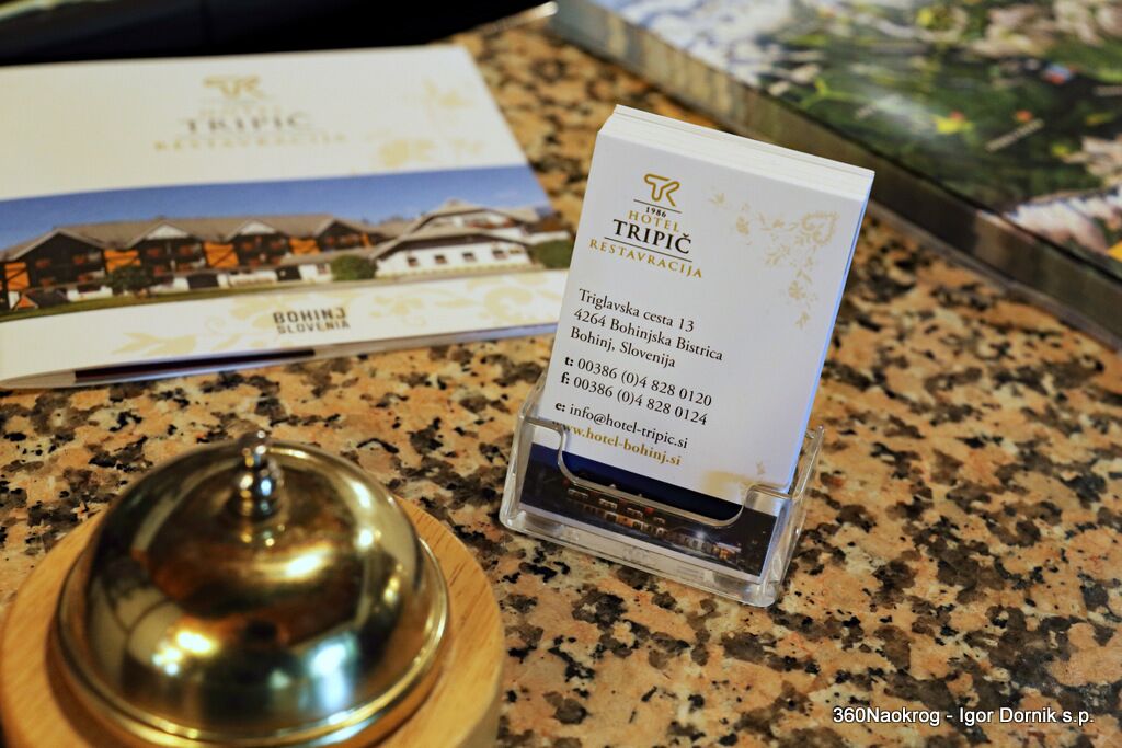 A hotel sign with contact information and a brochure on a counter.