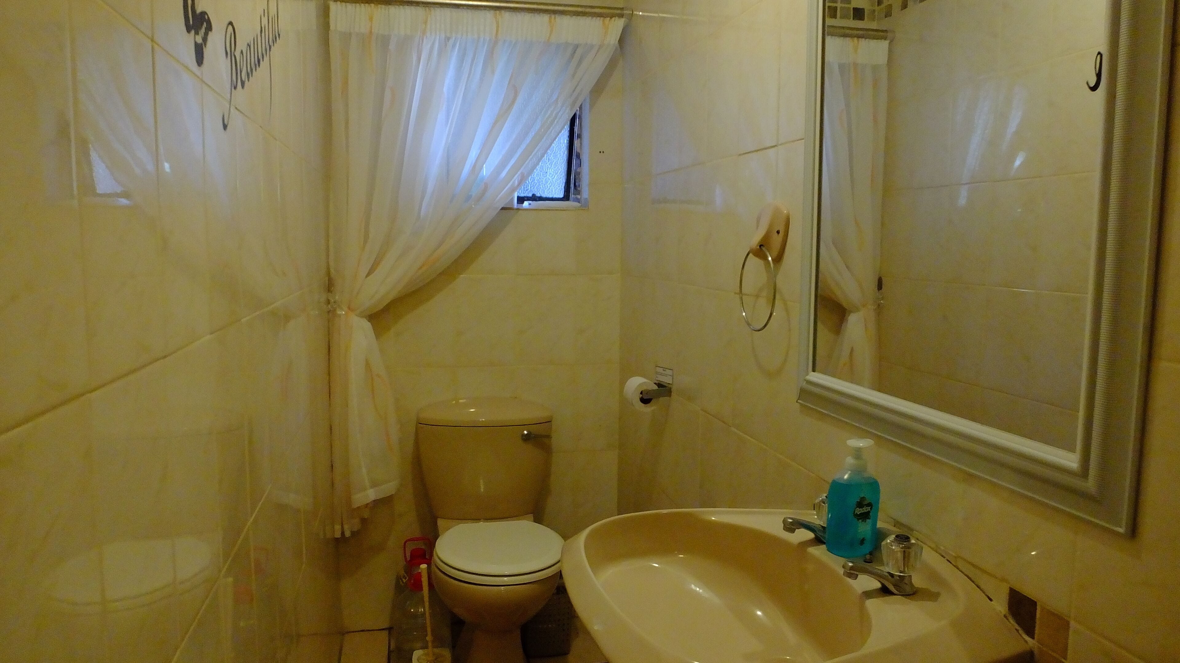 Un baño con inodoro, lavabo y espejo.
