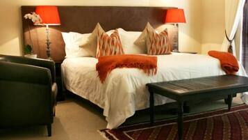 A neatly arranged bedroom with a bed, two bedside tables, a nightstand, and a red patterned rug.