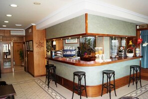 A bar area with a counter, stools, and a decorative wall. - Sandra II (Suances)