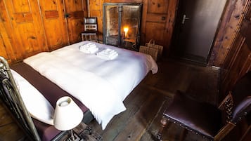 Una habitación de madera con una cama, una silla y una chimenea.