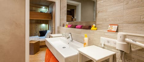 A bathroom with a large sink, a mirror, a towel rack, and a hairdryer.