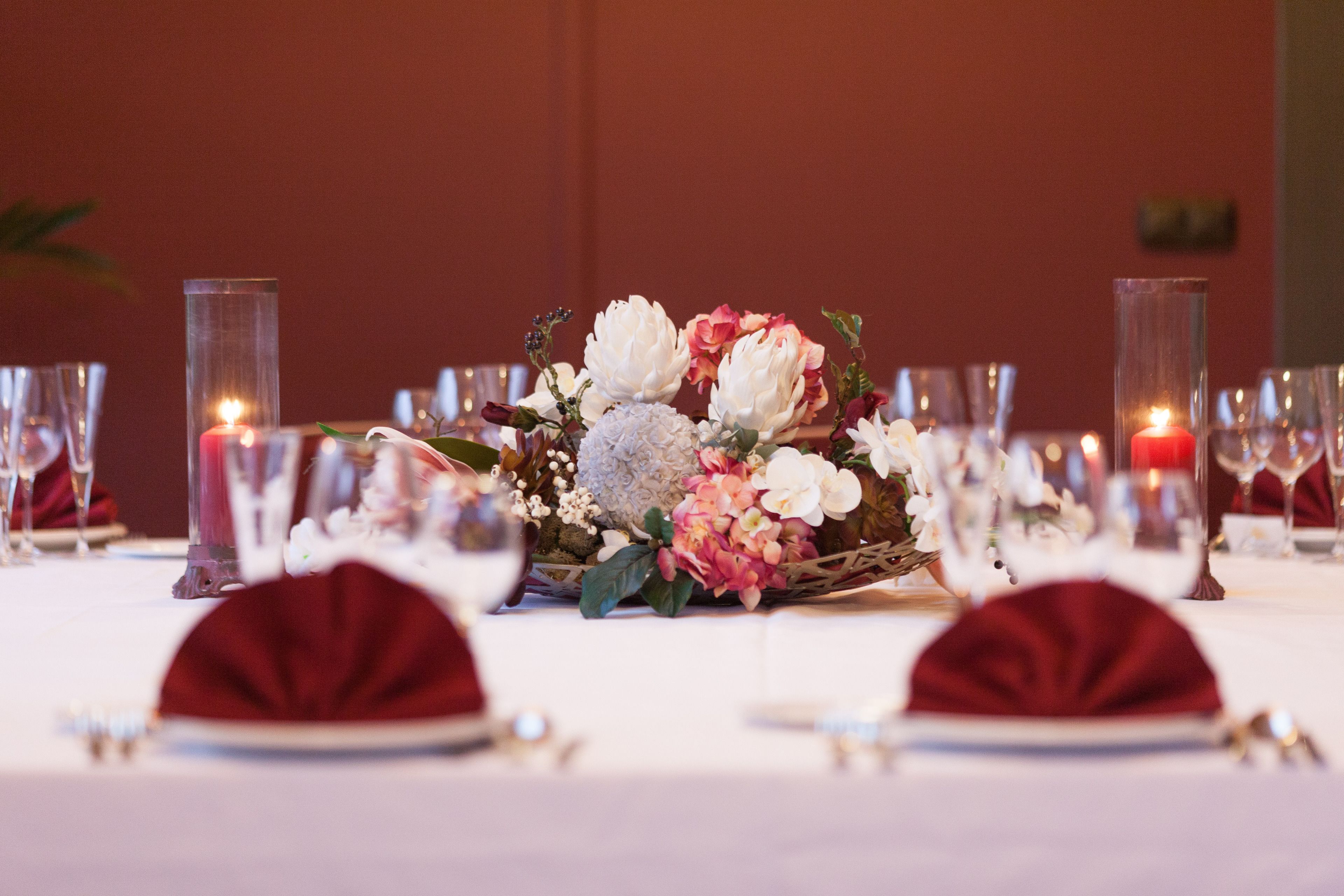 A table set for a formal dining occasion with a centerpiece of flowers and candles.