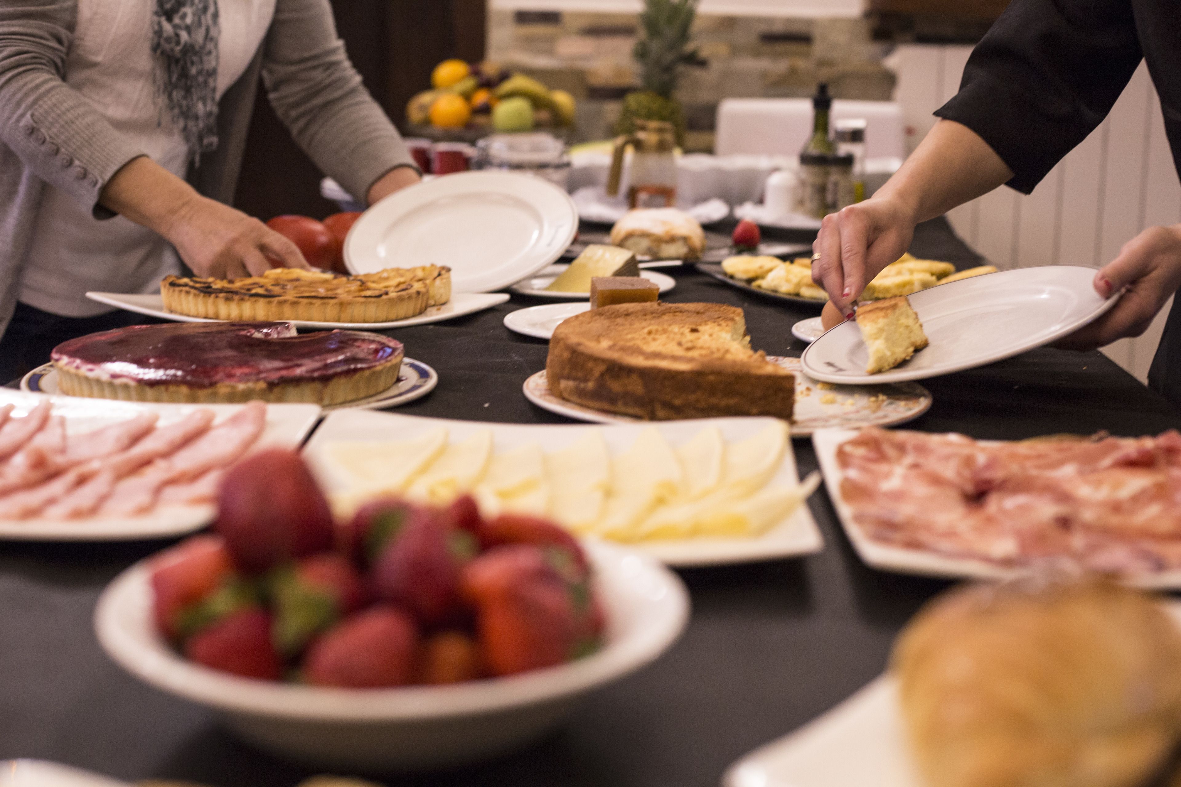 Una mesa de buffet con diversos alimentos, incluyendo carnes, quesos y frutas.