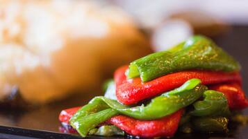 A close-up of a dish with sliced vegetables and a bun.