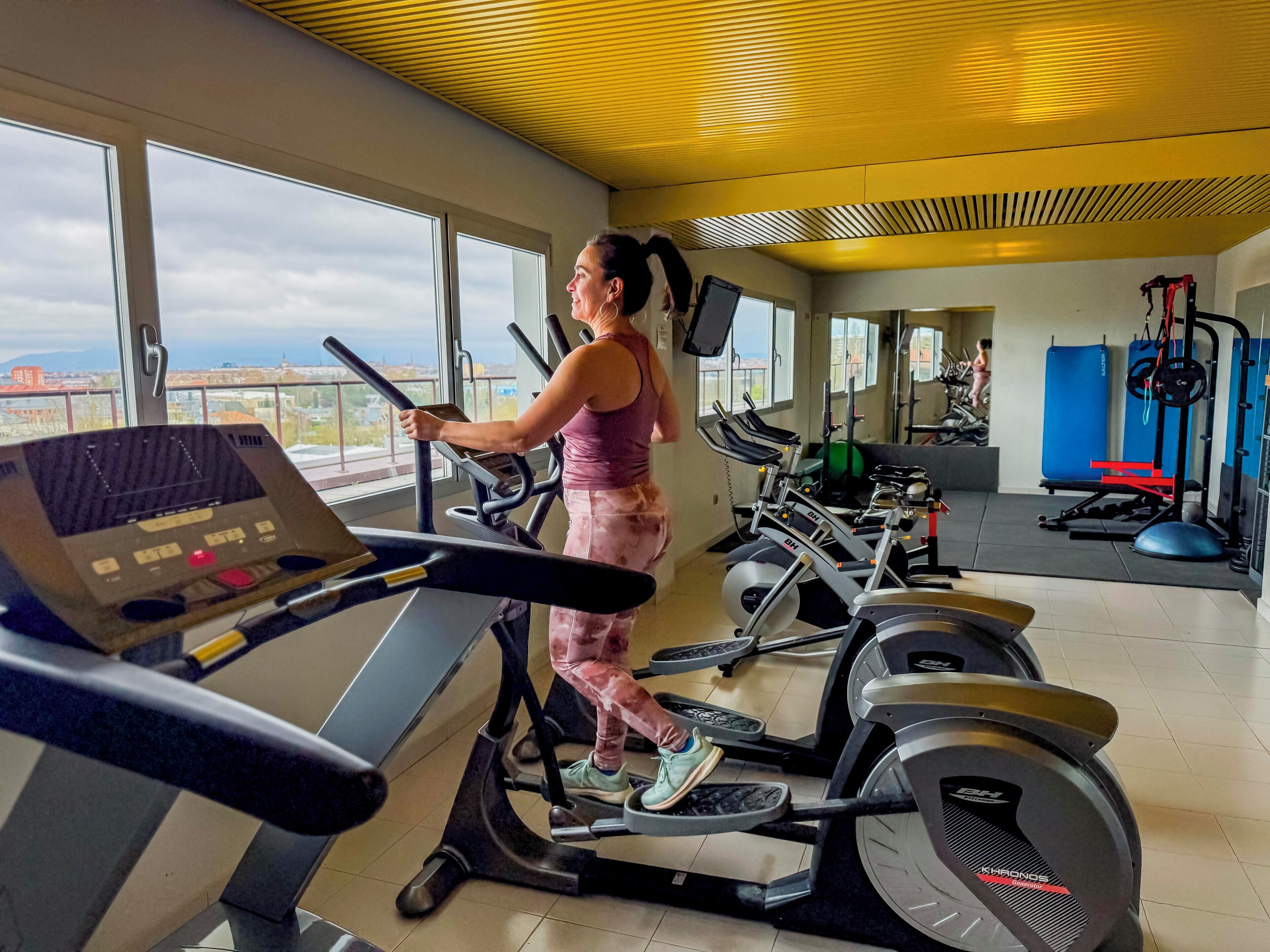 Un gimnasio con cintas de correr, bicicletas estáticas y máquinas de pesas.