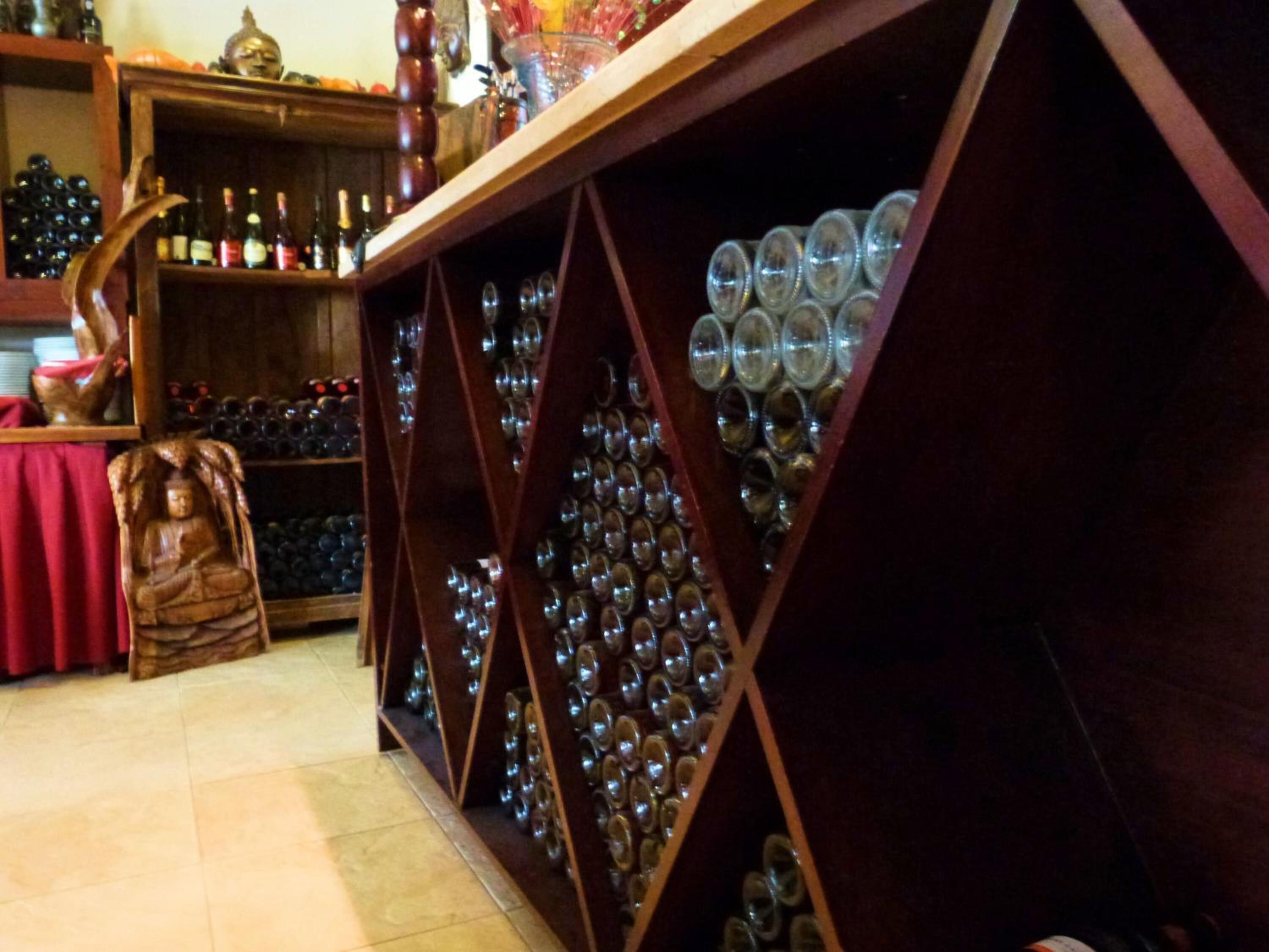 A wine cellar with wooden shelves and glass bottles.