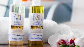Two bottles of BAL shampoo and conditioner on a towel with white flowers.