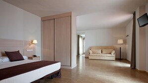 A hotel room with a bed, a sofa, a TV, and a lamp. - Hotel Balneario Areatza (Areatza)