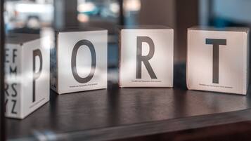 Three blocks with letters 'P', 'O', 'R', 'T' on a wooden surface.