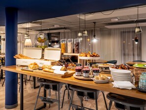 A breakfast buffet with bread, pastries, and various spreads.