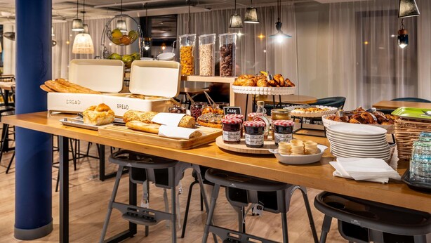 A breakfast buffet with bread, pastries, and various spreads.
