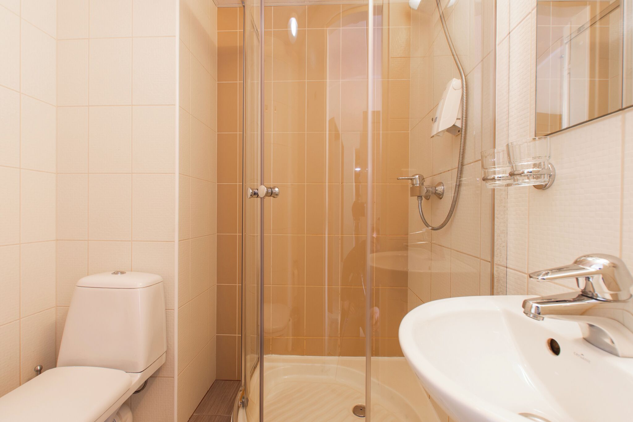 Une salle de bain avec une douche à parois de verre, des toilettes et un lavabo avec un miroir.