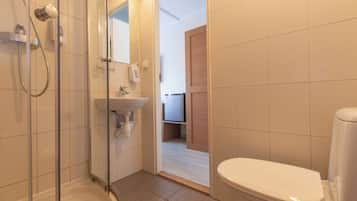 Un bagno con cabina doccia in vetro, lavandino e water.