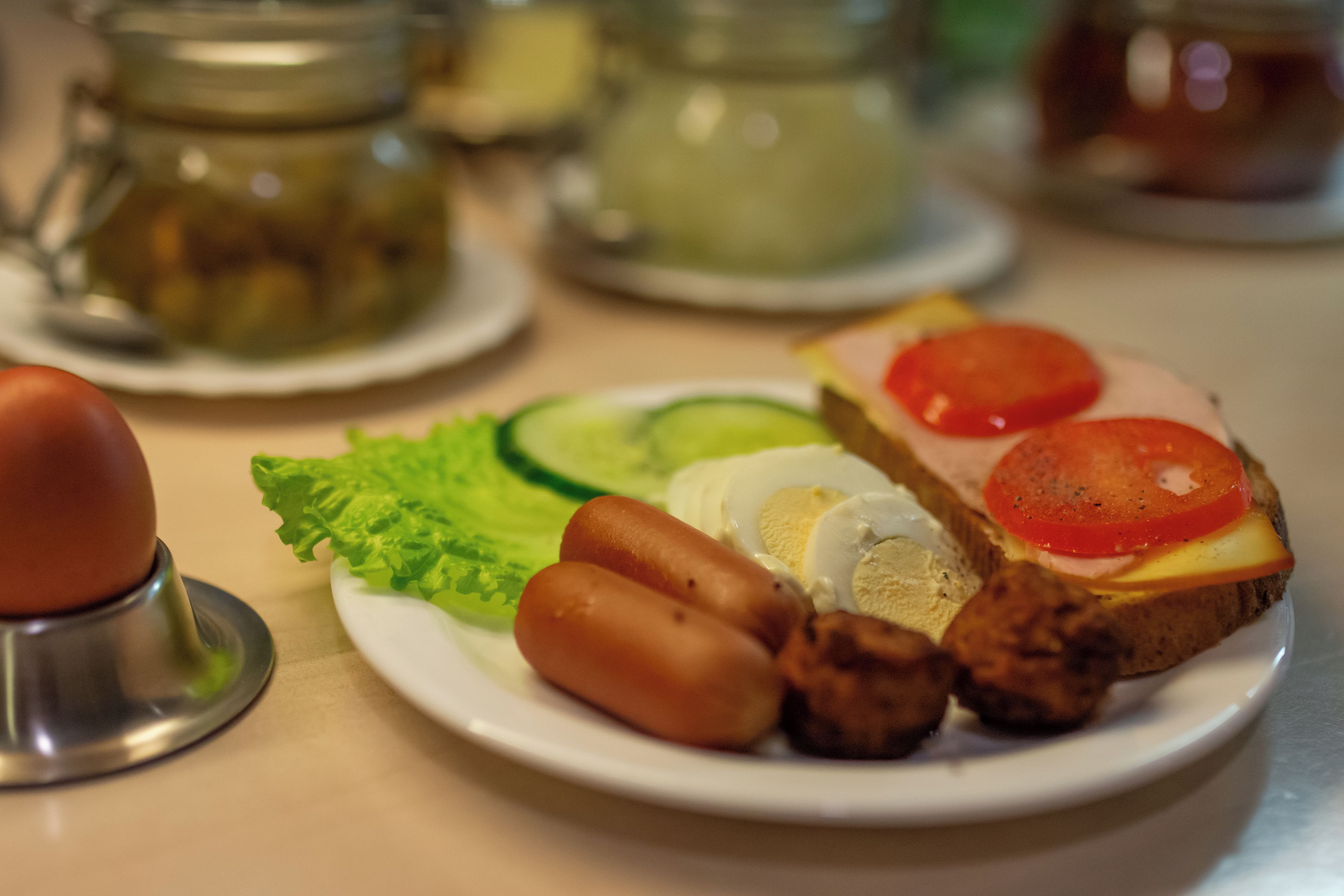 A plate with a sandwich, eggs, and vegetables.