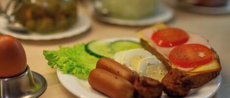 A plate with a sandwich, eggs, and vegetables.