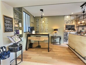 Um café moderno com uma mesa de madeira, um laptop e um menu em lousa.