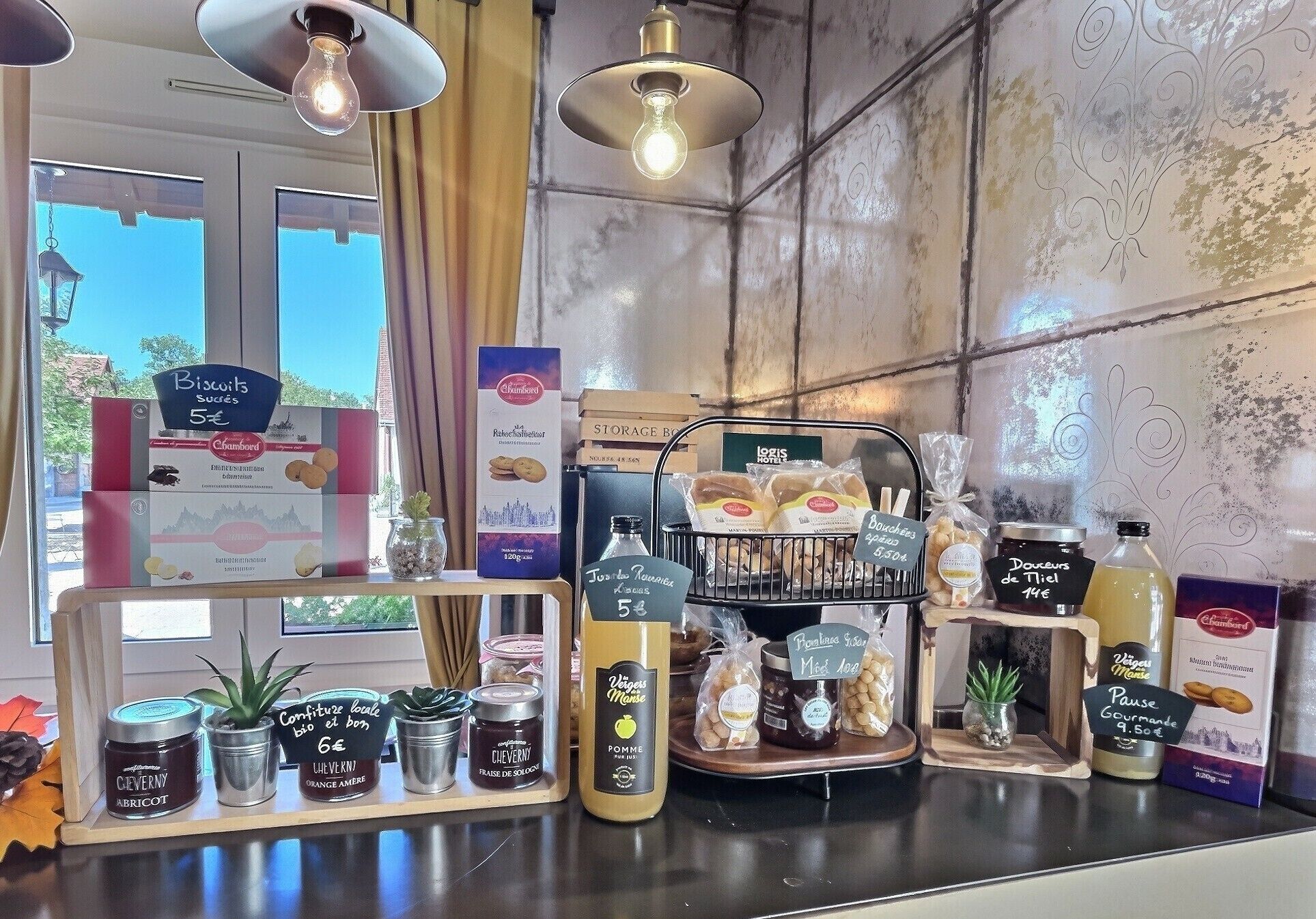 Una vitrina de panadería con diversos productos horneados y frascos de conservas.