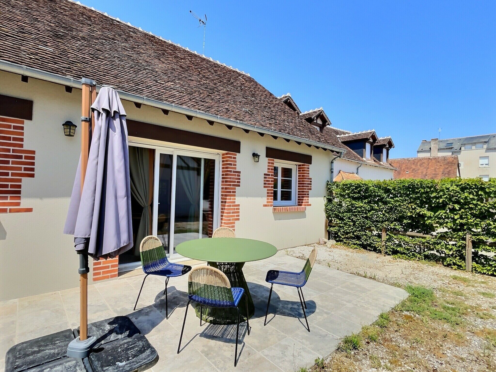 A house with a patio, a table, and chairs.
