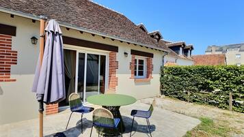 A house with a patio, a table, and chairs.