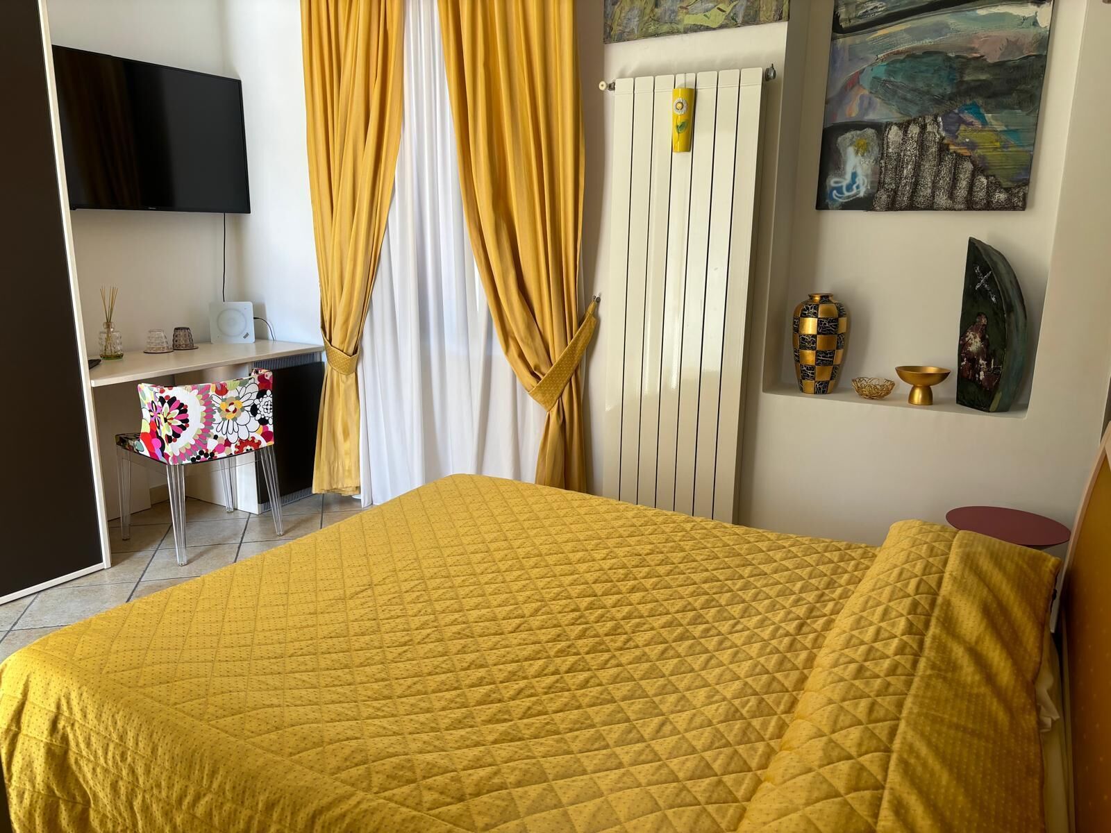 A room with a bed, a desk, a chair, and a TV.