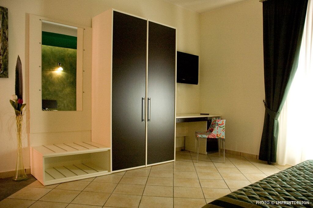 Une chambre avec une armoire, un bureau, une chaise et un lit.