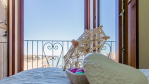 A balcony with a lace chair and a bowl of colorful eggs. - Residenza Sveva (Termoli)