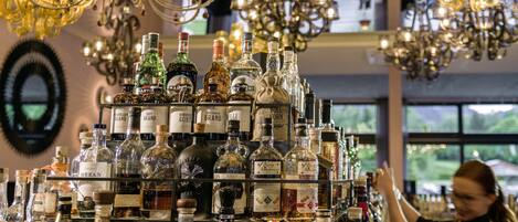 Zona de bar con varias botellas de licor y una araña.