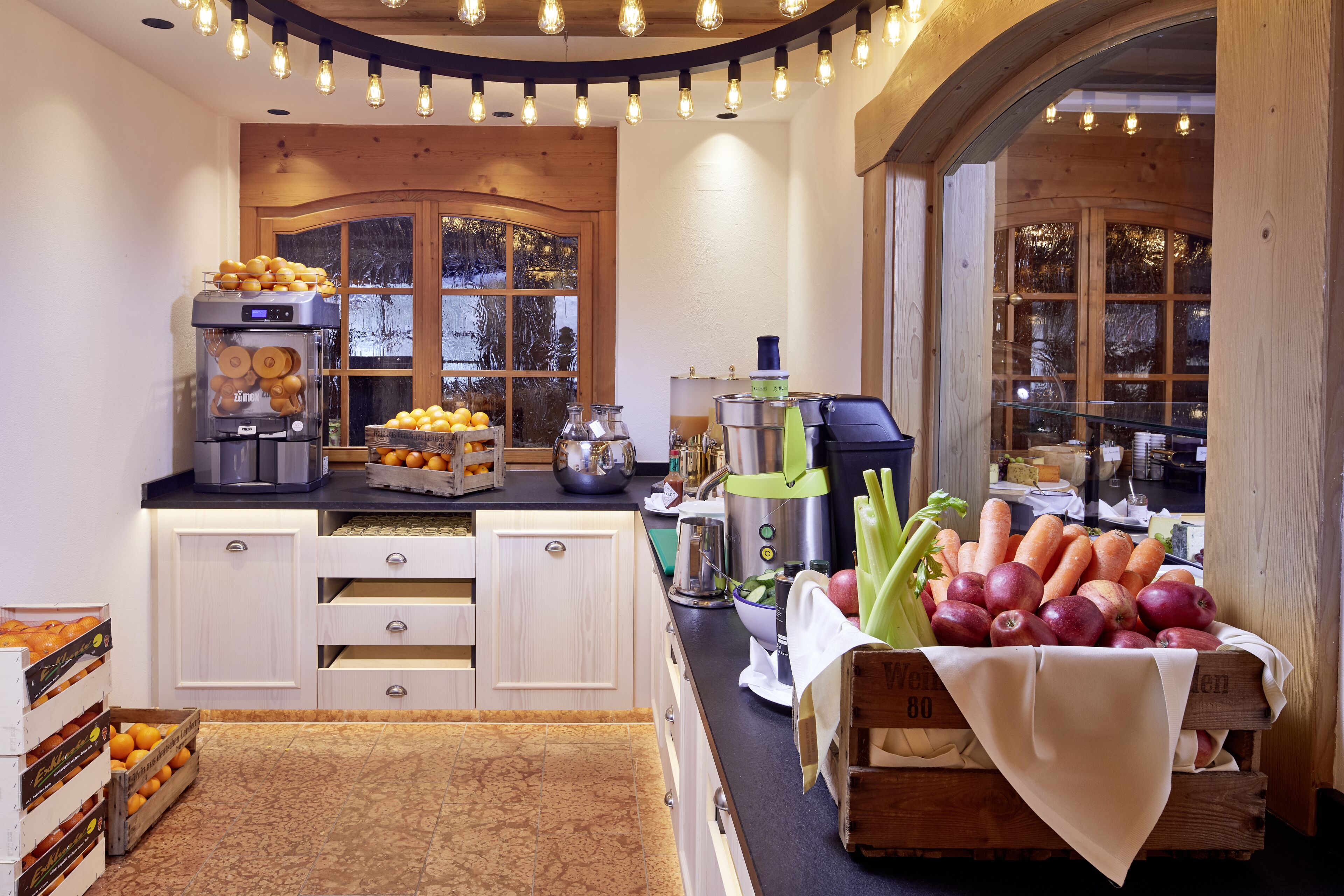 A kitchen with a coffee machine, fruit display, and wooden cabinets.