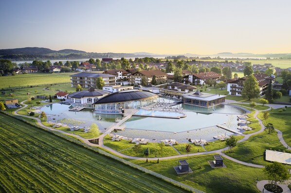 A resort with multiple buildings, a large central pool, and surrounding green lawns. - Das König Ludwig - Adult Only (Schwangau)