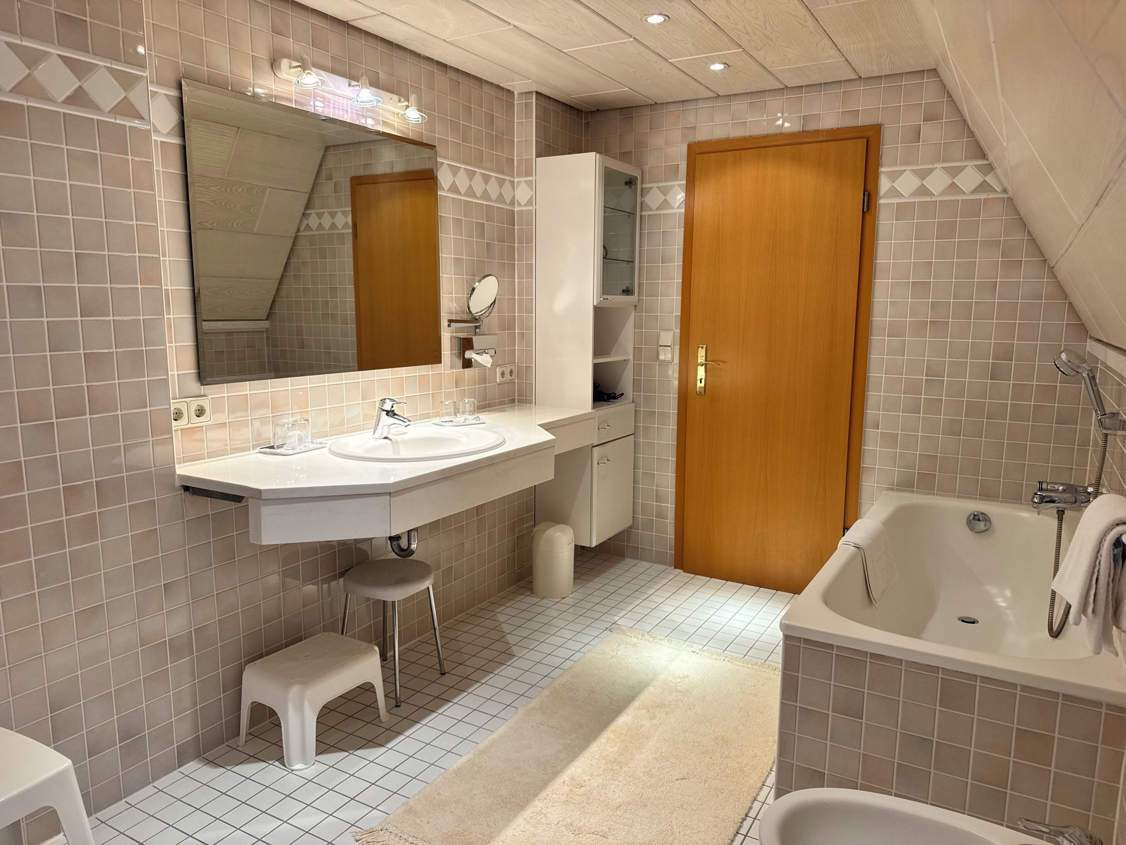 A bathroom with a sink, mirror, cabinet, toilet, and bathtub.