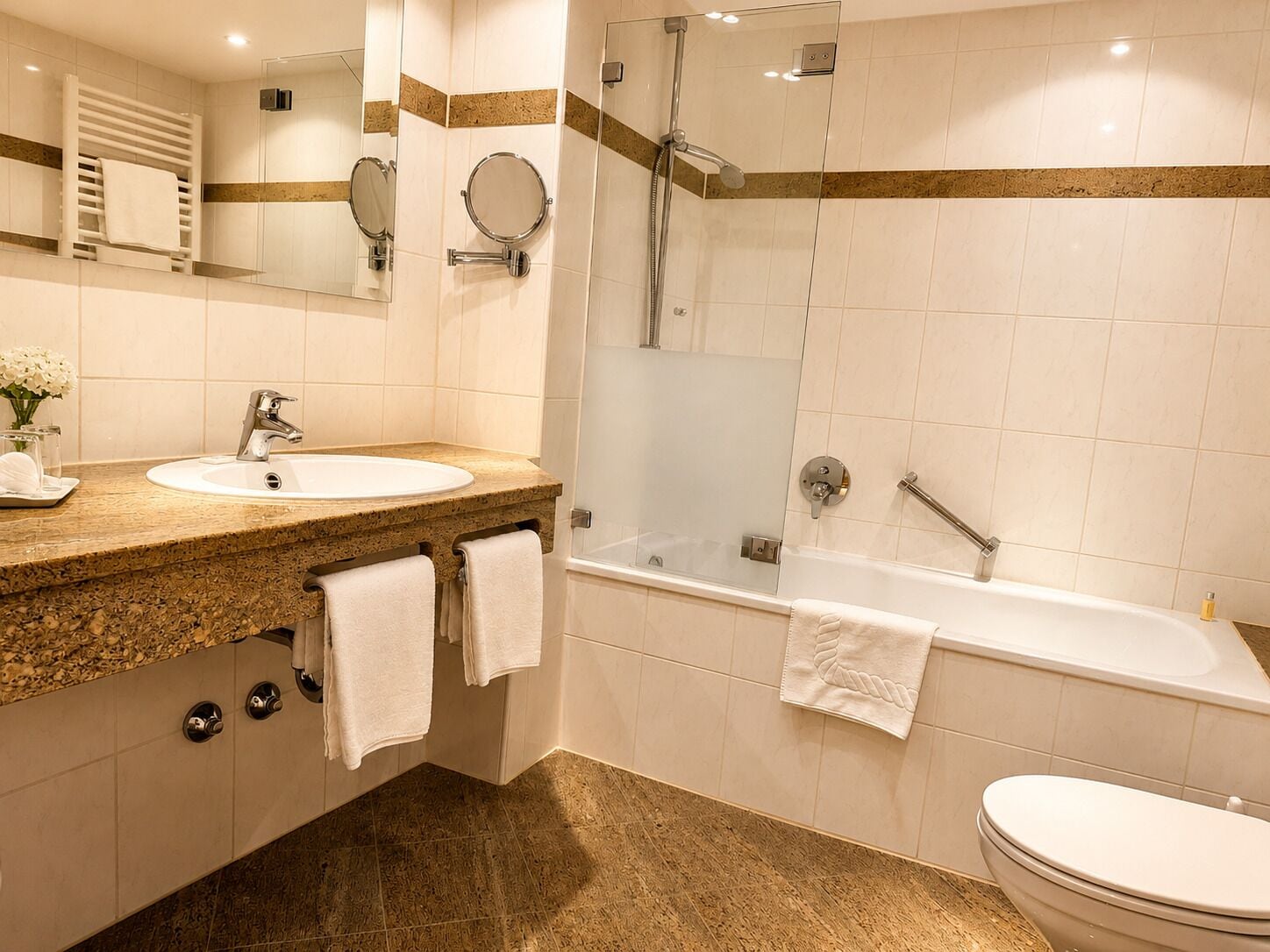 A modern bathroom with a sink, mirror, and shower.