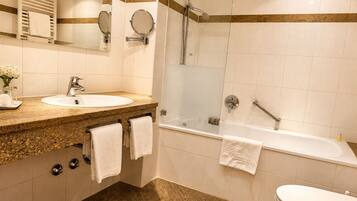 A modern bathroom with a sink, mirror, and shower.